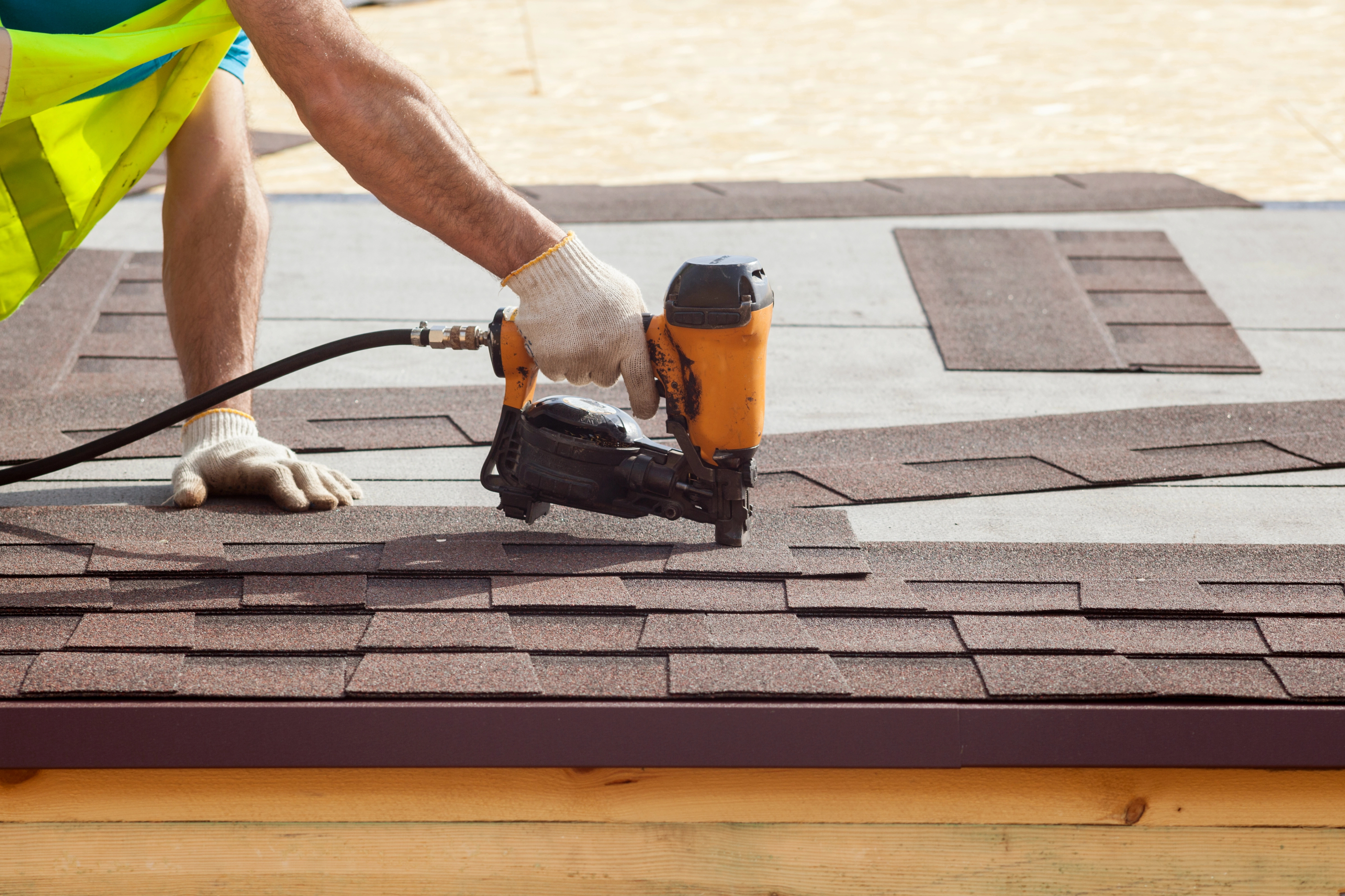 Roofer installing asphalt shingles