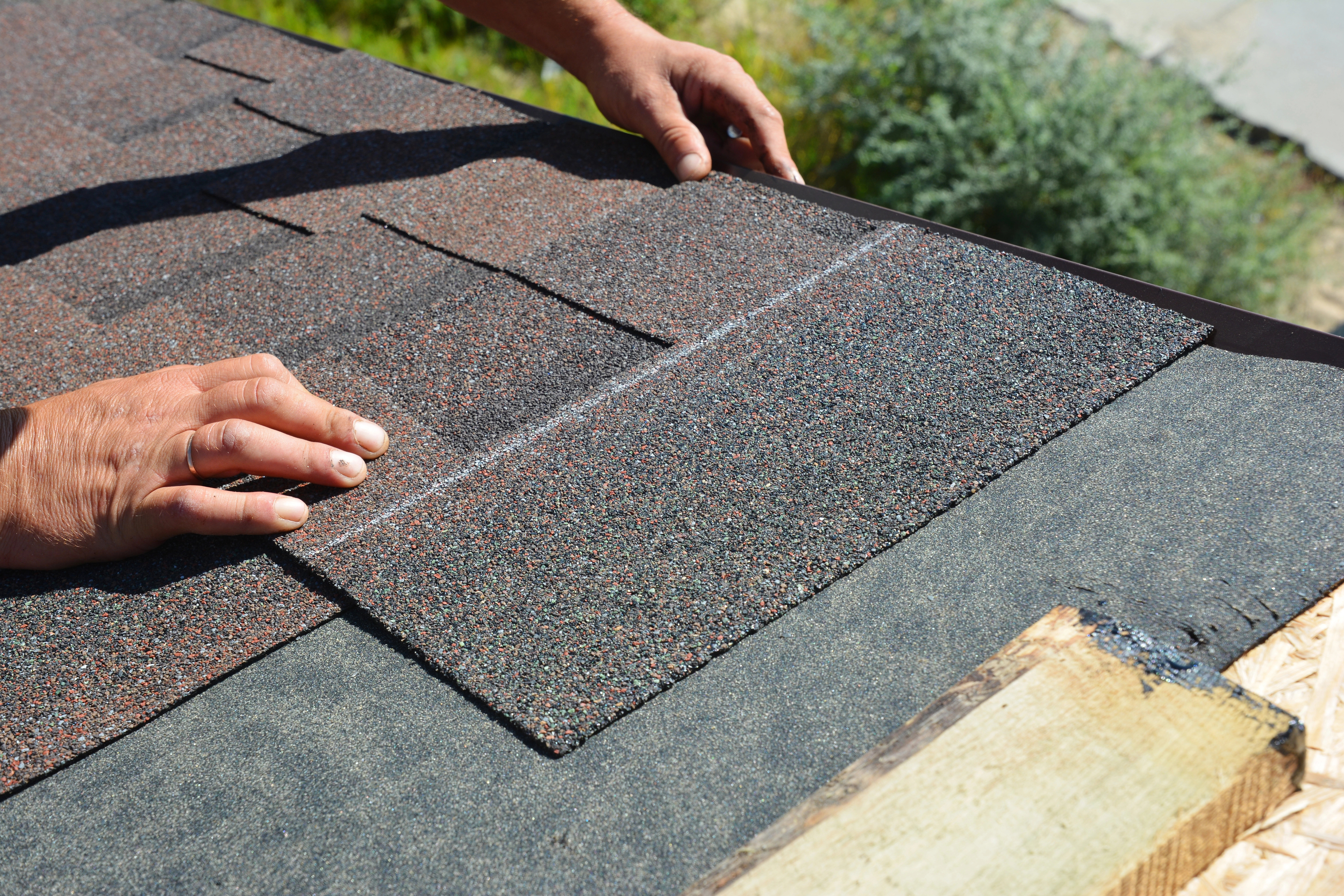Roofer installing asphalt shingles